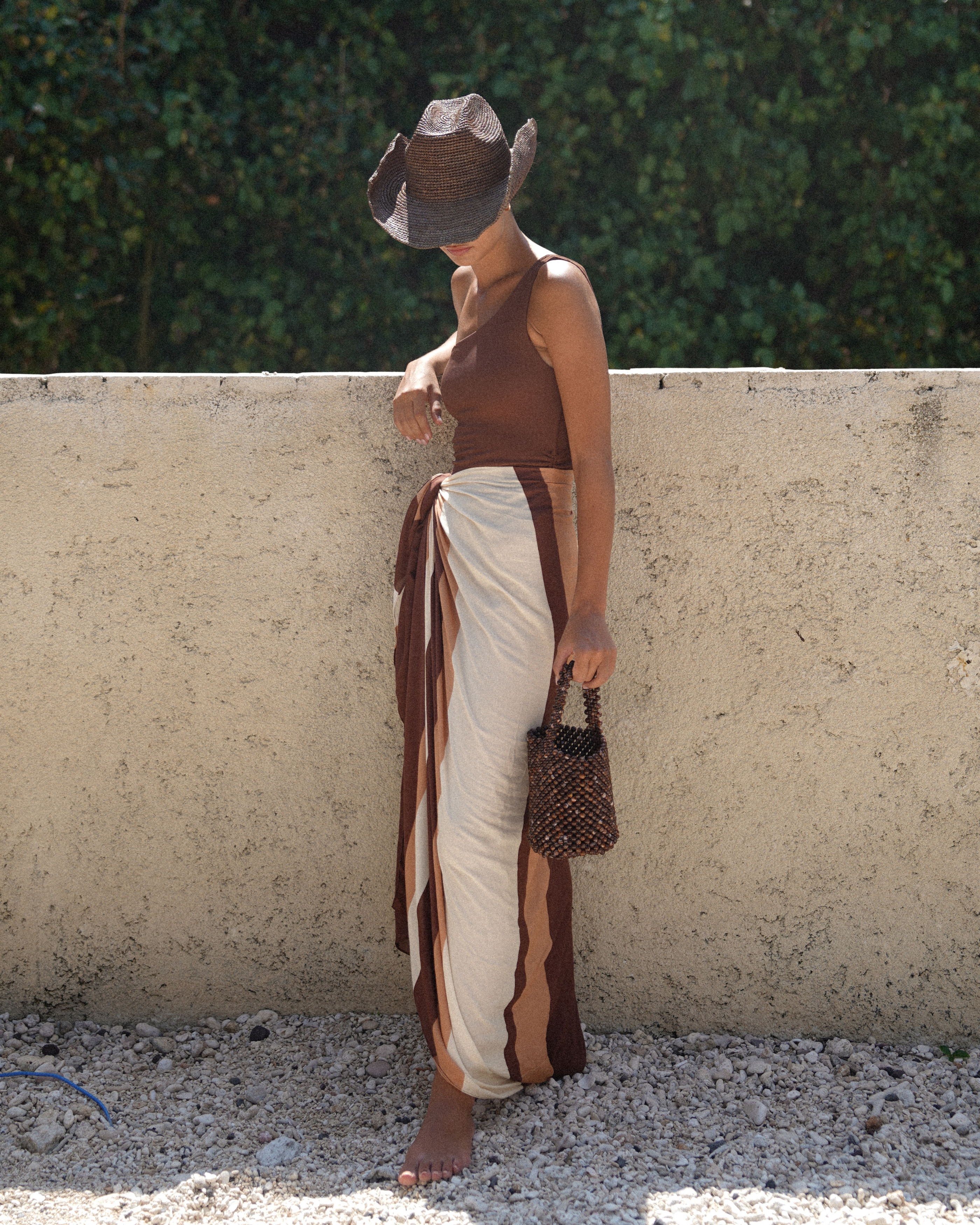 Dark brown raffia cowboy hat with adjustable band and luxury resortwear aesthetic.