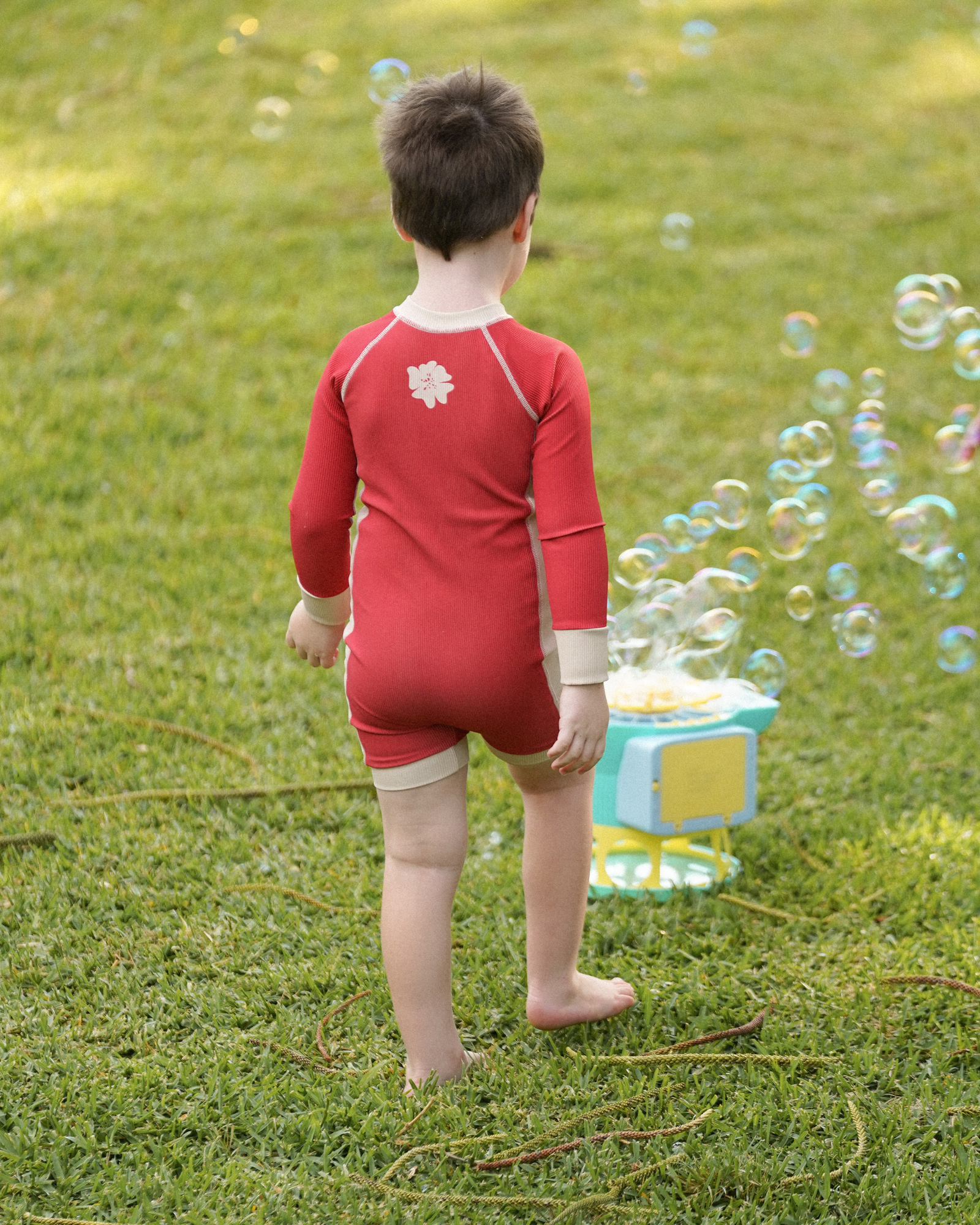 Children’s melon long sleeve surfsuit with soft stretch fabric and cream detailing