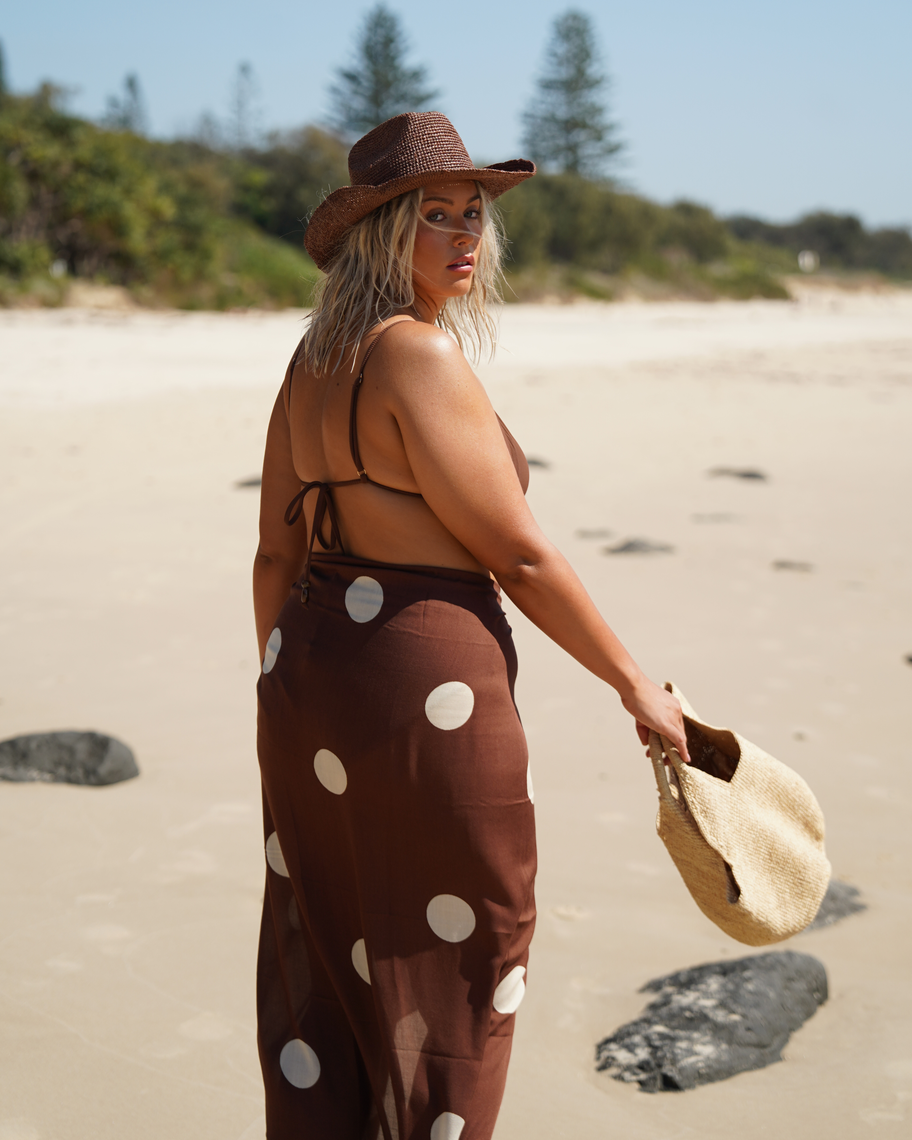 Back view of resortwear outfit featuring brown and cream polkadot beach sarong