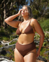 Plus-size model wearing chocolate ribbed high waist bikini bottom by Ochre Lane, styled with matching top.