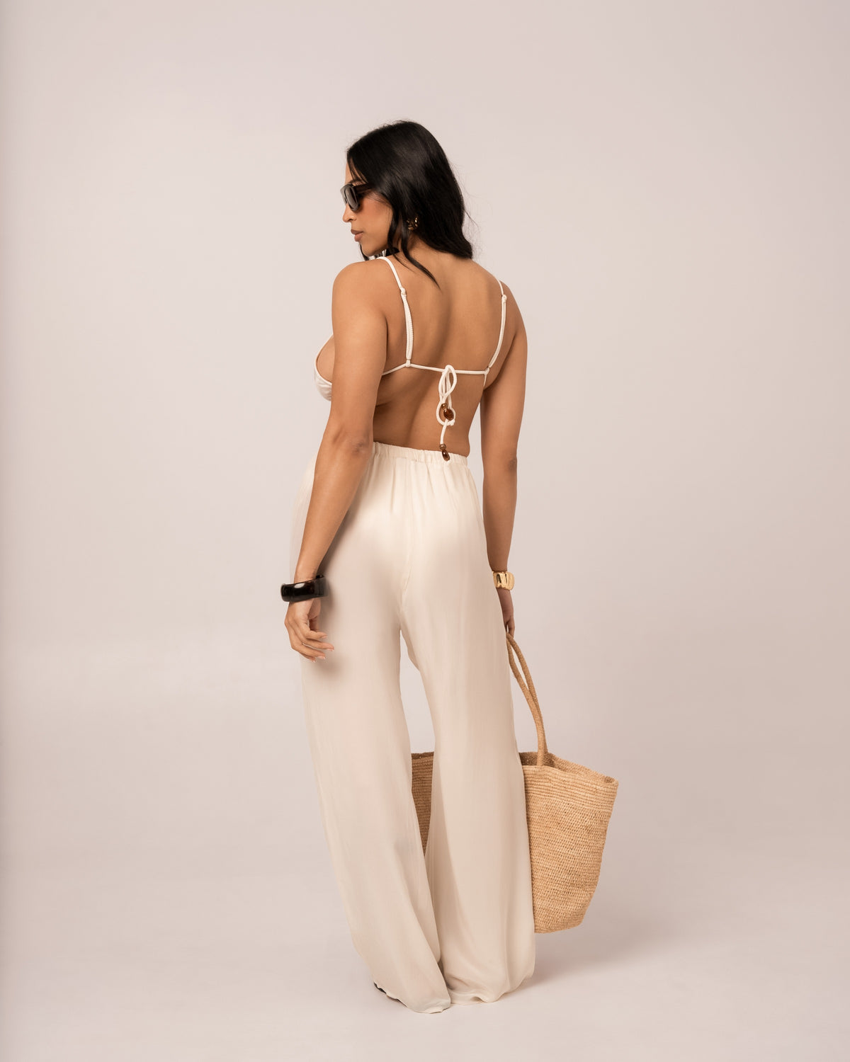Back view of the ivory wide-leg resort pant with its relaxed drawstring waist and full-length hem