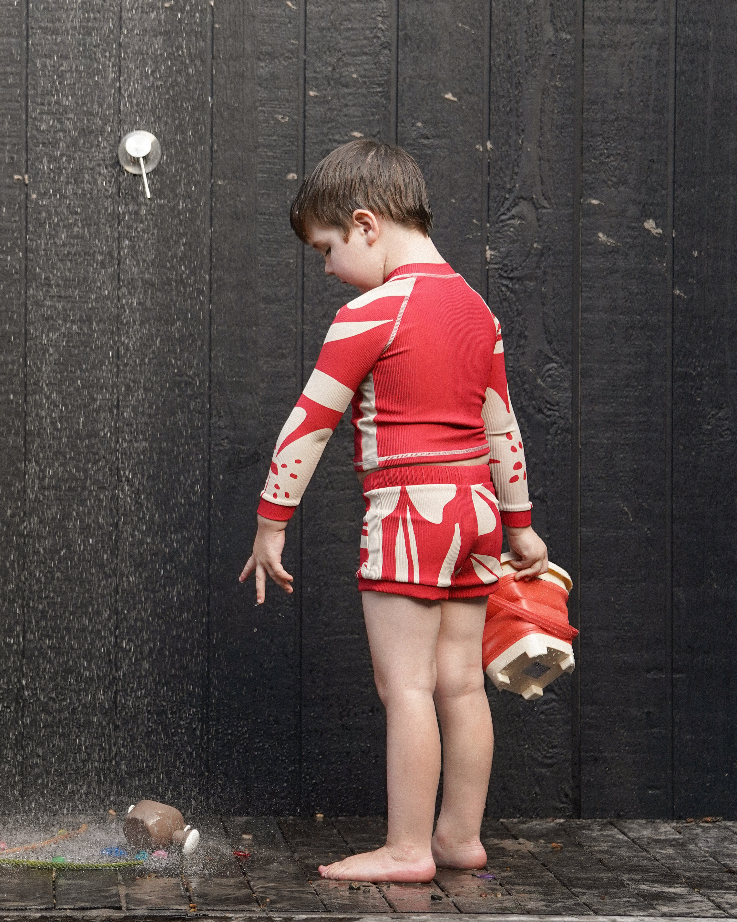 Kids Solana print red swim shorts paired with matching rash shirt in natural light