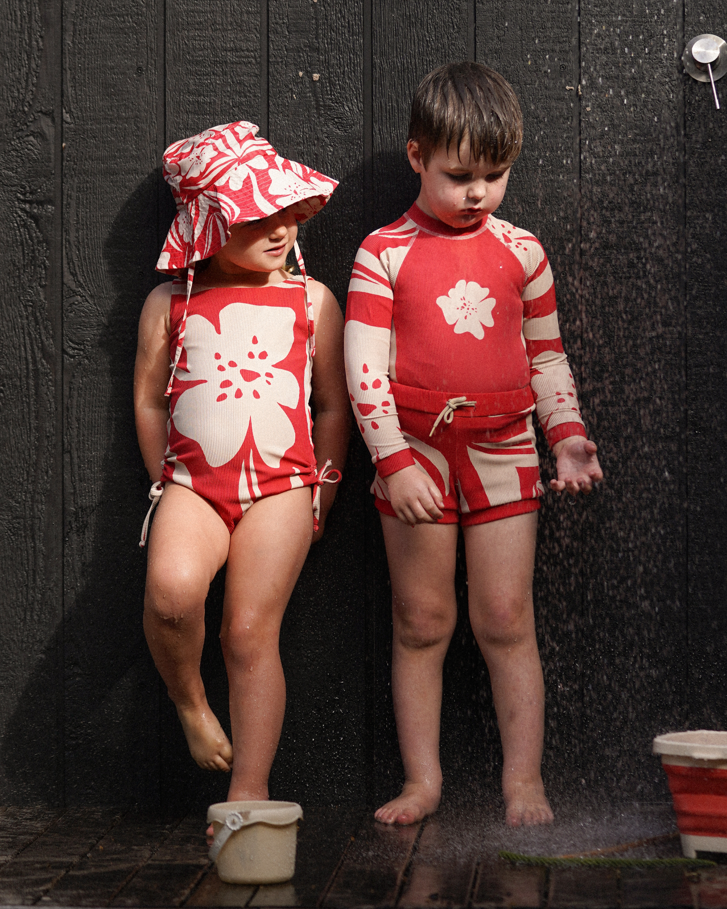 Red floral swim shorts for children with cream hibiscus detailing by Ochre Lane