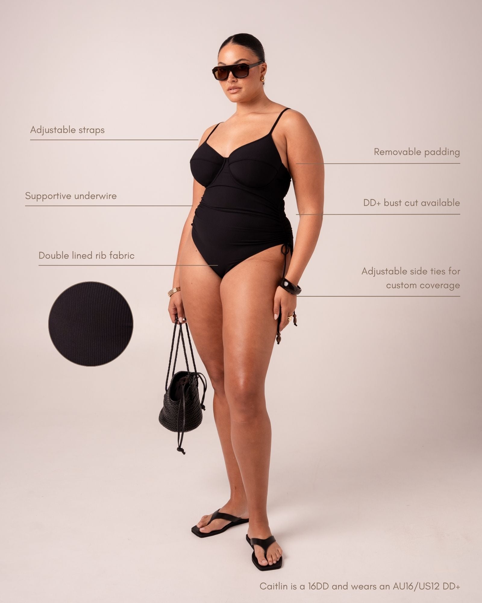 Black ribbed one-piece swimsuit with thin adjustable straps, underwire, removable padding, and adjustable side ties, shown on a plus-size model with fabric swatch and feature callouts.