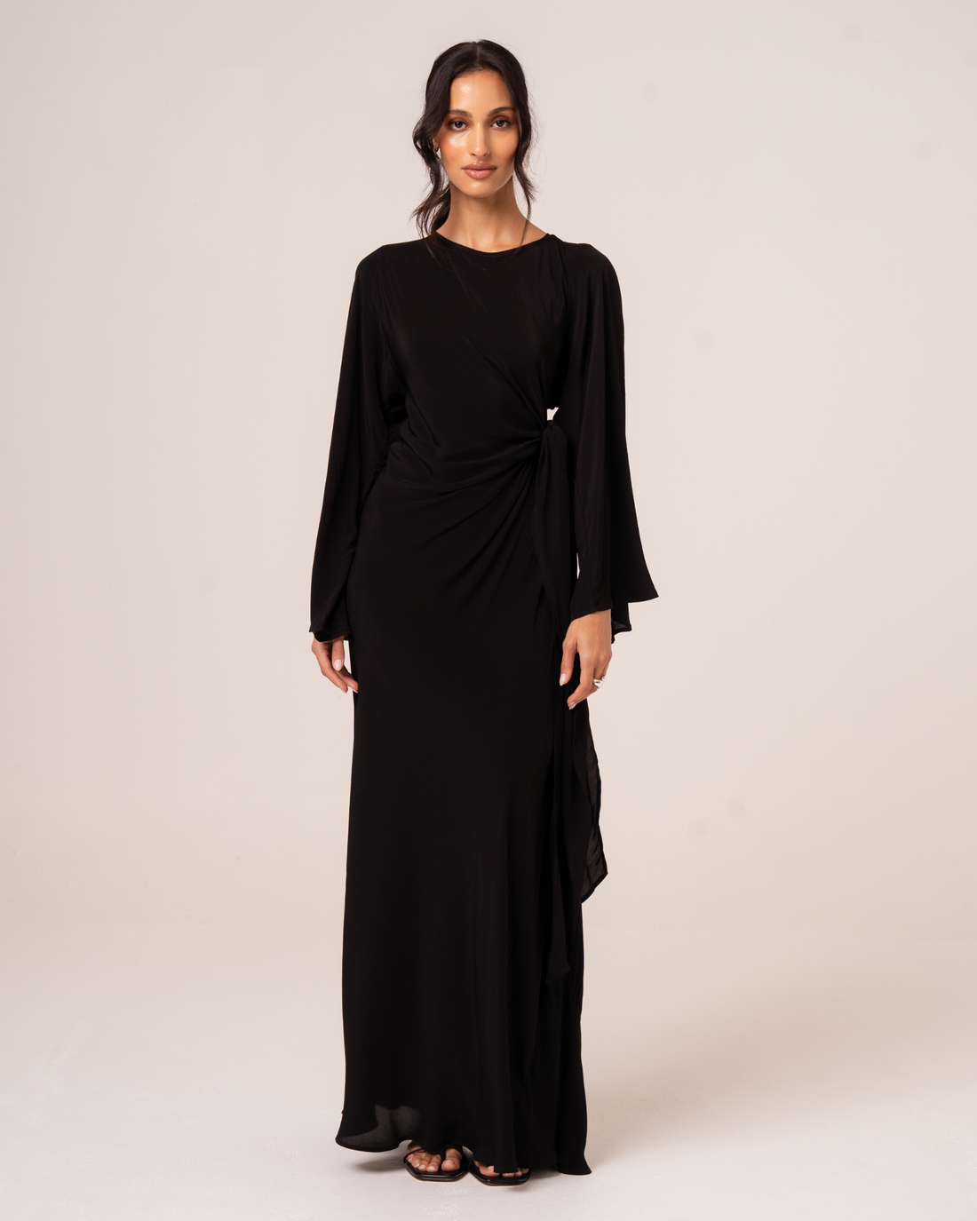 Black batwing maxi dress with draped knot waist detail, front view, studio