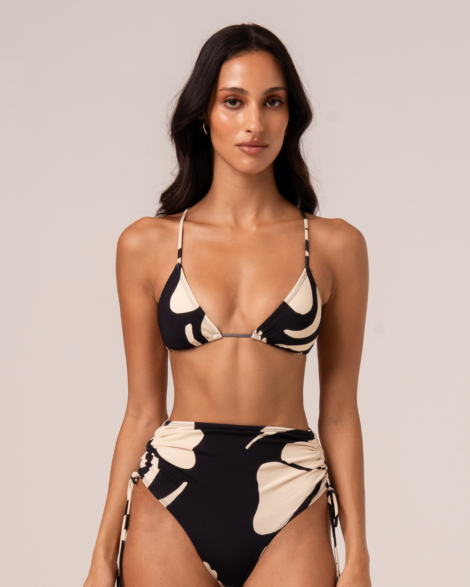 Black and cream botanica floral print string triangle bikini top, front view, styled with matching high-waisted tie-side bottom