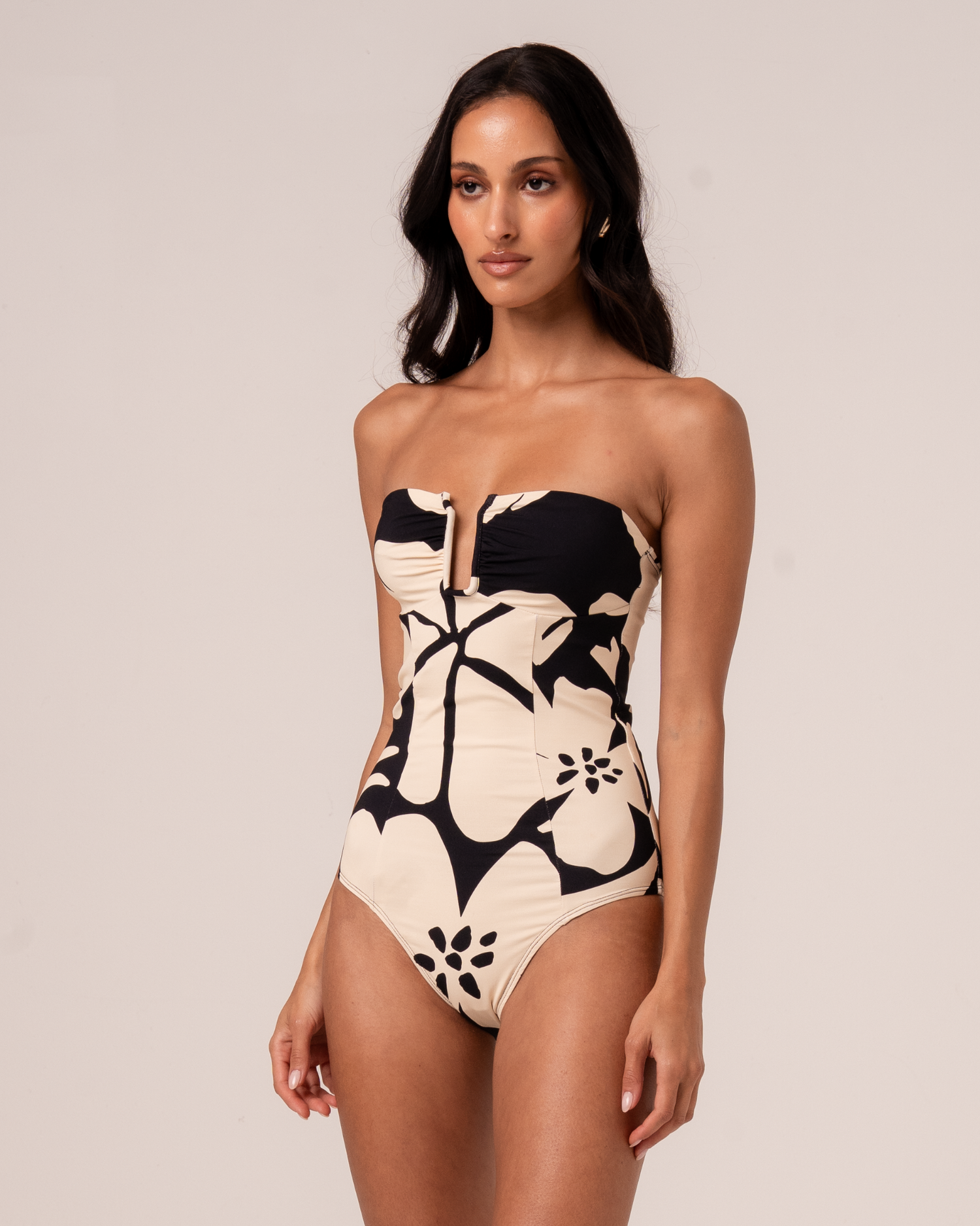 Botanica floral print sculpted bandeau one-piece swimsuit in black and cream with sculpted V-notch bust, three-quarter studio view