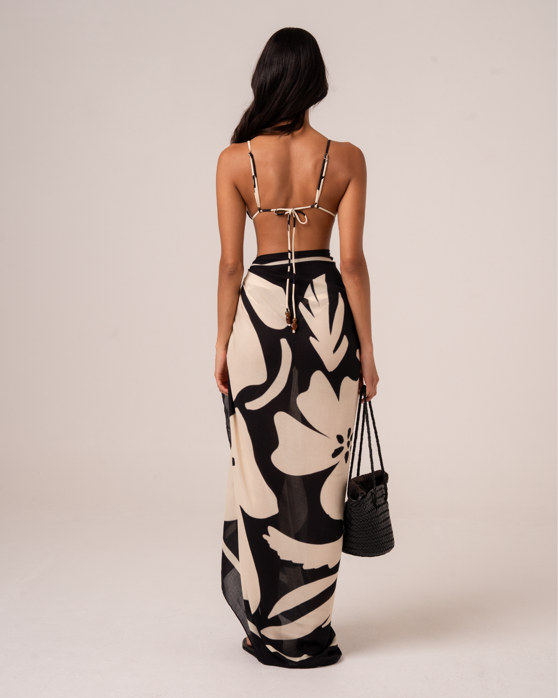 Black and cream floral Botanica Sarong worn as a versatile pareo wrap for resort styling
