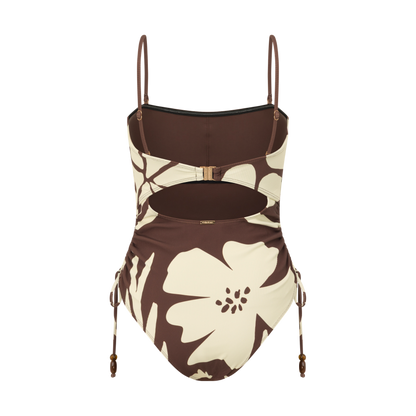 Back view of a brown and cream floral print one-piece swimsuit with a cut-out back, ring buckle closure and ruched side-tie detail, studio flat lay