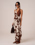 Front view of a brown and cream floral wrap maxi dress showing the draped side knot and floor-length column silhouette