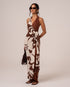 Side view of a brown and cream floral halter wrap maxi dress with a cascading waist tie drape, studio setting