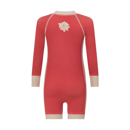 Back view of a coral melon kids surf suit showing the cream flower graphic between the shoulders and contrast cuffs