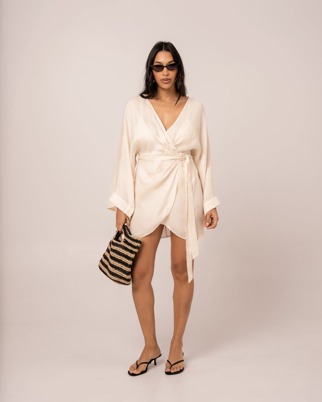 Ivory batwing wrap mini dress with a deep V neckline and self-tie waist, shown from the front
