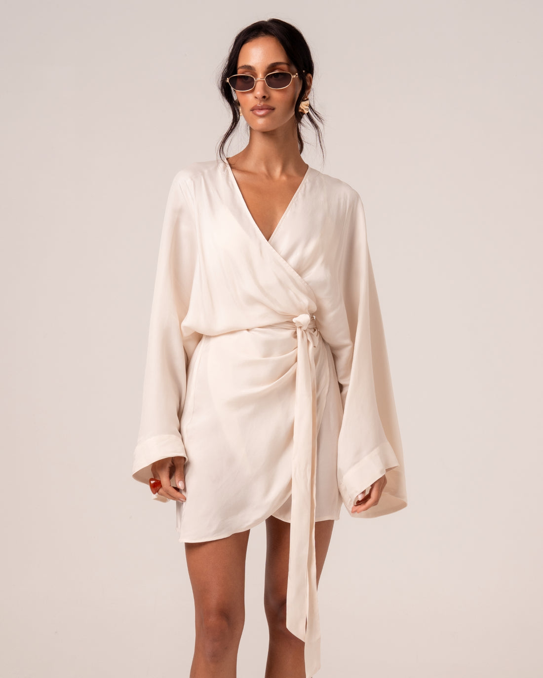 Ivory batwing wrap mini dress with a deep V-neck and self-tie waist, front view — honeymoon resortwear