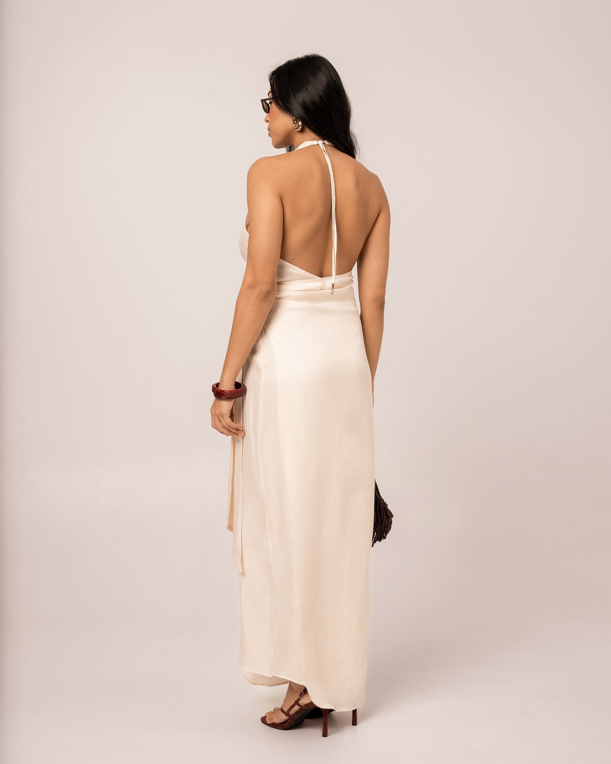 Back view of an ivory halter wrap maxi dress showing the deep open back and self-tie halter neck