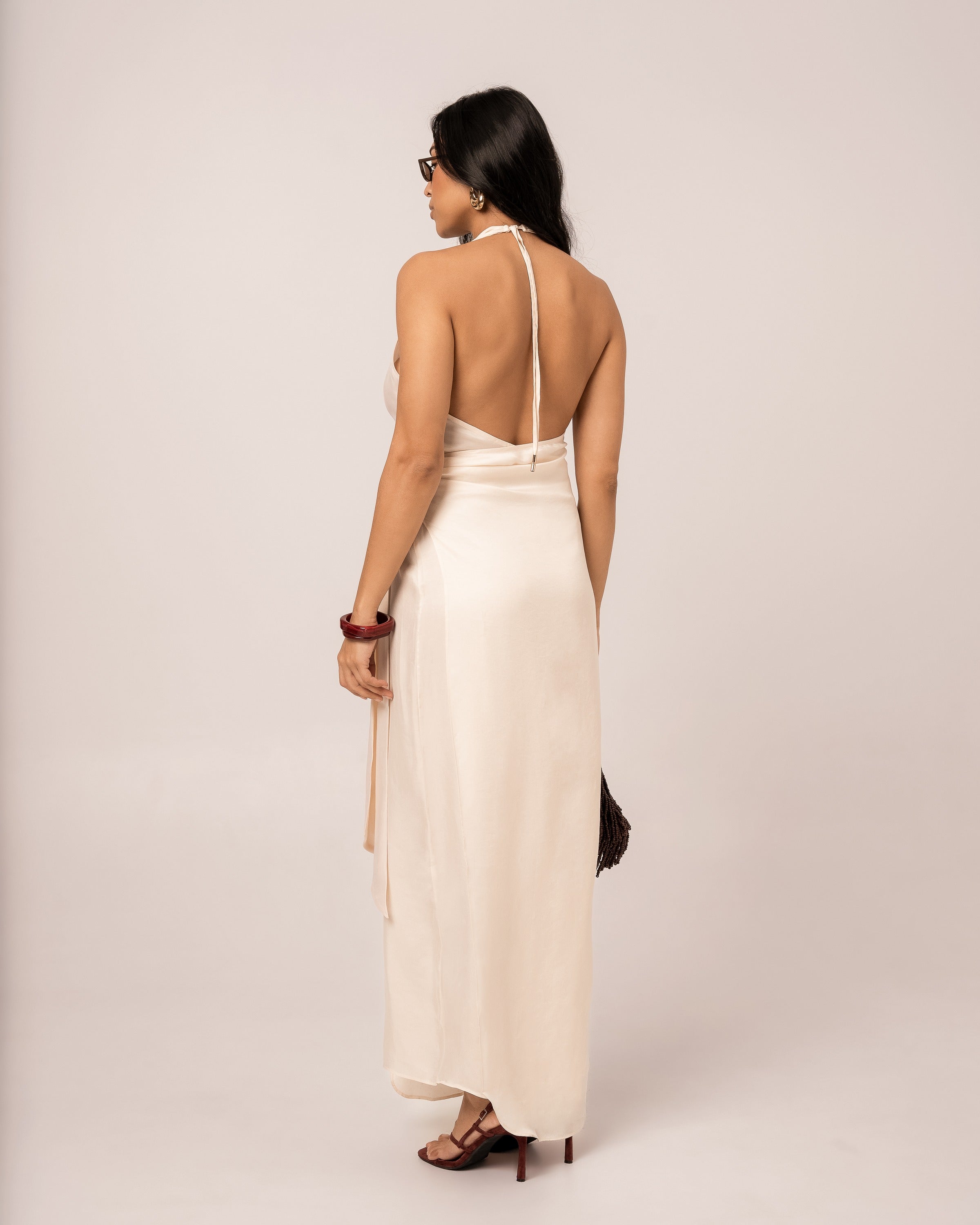 Back view of an ivory halter wrap maxi dress showing the deep open back and self-tie halter neck