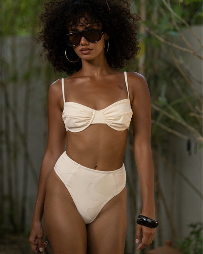 Ivory soft cup bralette and high waist bottom worn at a tropical resort — honeymoon swimwear