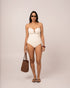 Model wearing an ivory strapless bandeau one piece swimsuit with a V-wire plunge neckline, studio front view