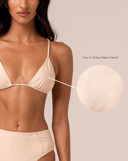 Model wearing an ivory string triangle bikini top with thin adjustable straps, styled with a high waist bottom — studio front view