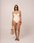 Model wearing an ivory thin strap underwire one piece swimsuit with structured cups, studio front view