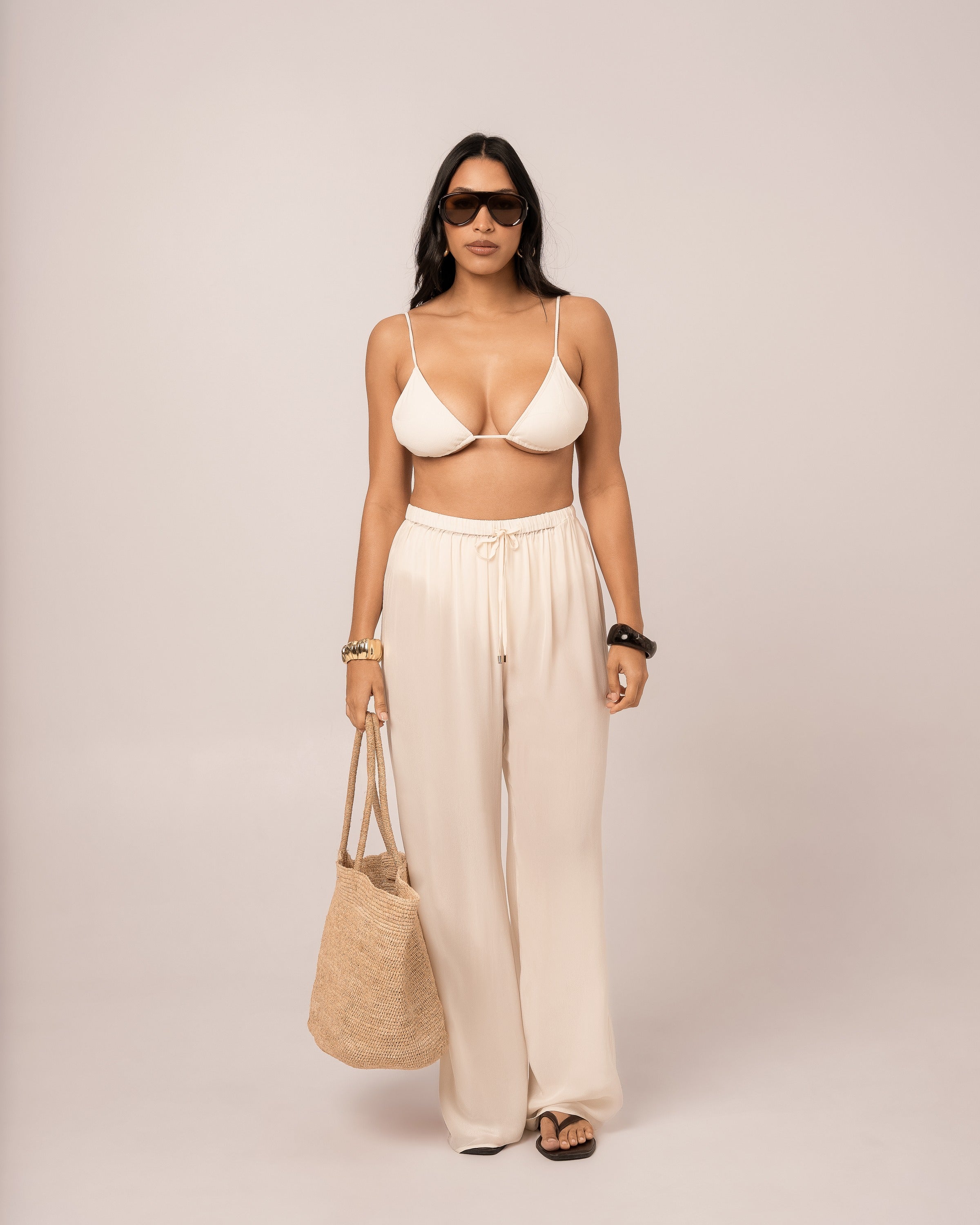 Ivory wide-leg viscose resort pant with a drawstring waist worn with a bikini top, front studio view