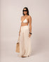 Side view of the ivory wide-leg resort pant showing its long column-like flowing leg line
