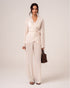 Model wearing an ivory viscose wrap shirt with self-tie waist and tulip hem over matching wide-leg resort pants, front view