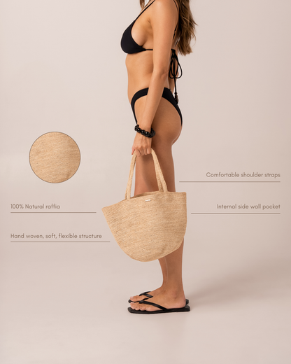 Infographic of a natural raffia straw mini tote bag on a model, highlighting comfortable shoulder straps, an internal side wall pocket, and hand-woven 100% natural raffia construction
