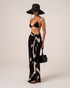 Ochre Lane Noir Dot Sarong in black polkadot print, a lightweight beach cover-up over swimwear
