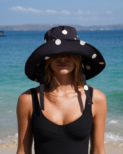 Ochre Lane Sun Hat in black polkadot print, wide brim bucket design for beach and resort styling.