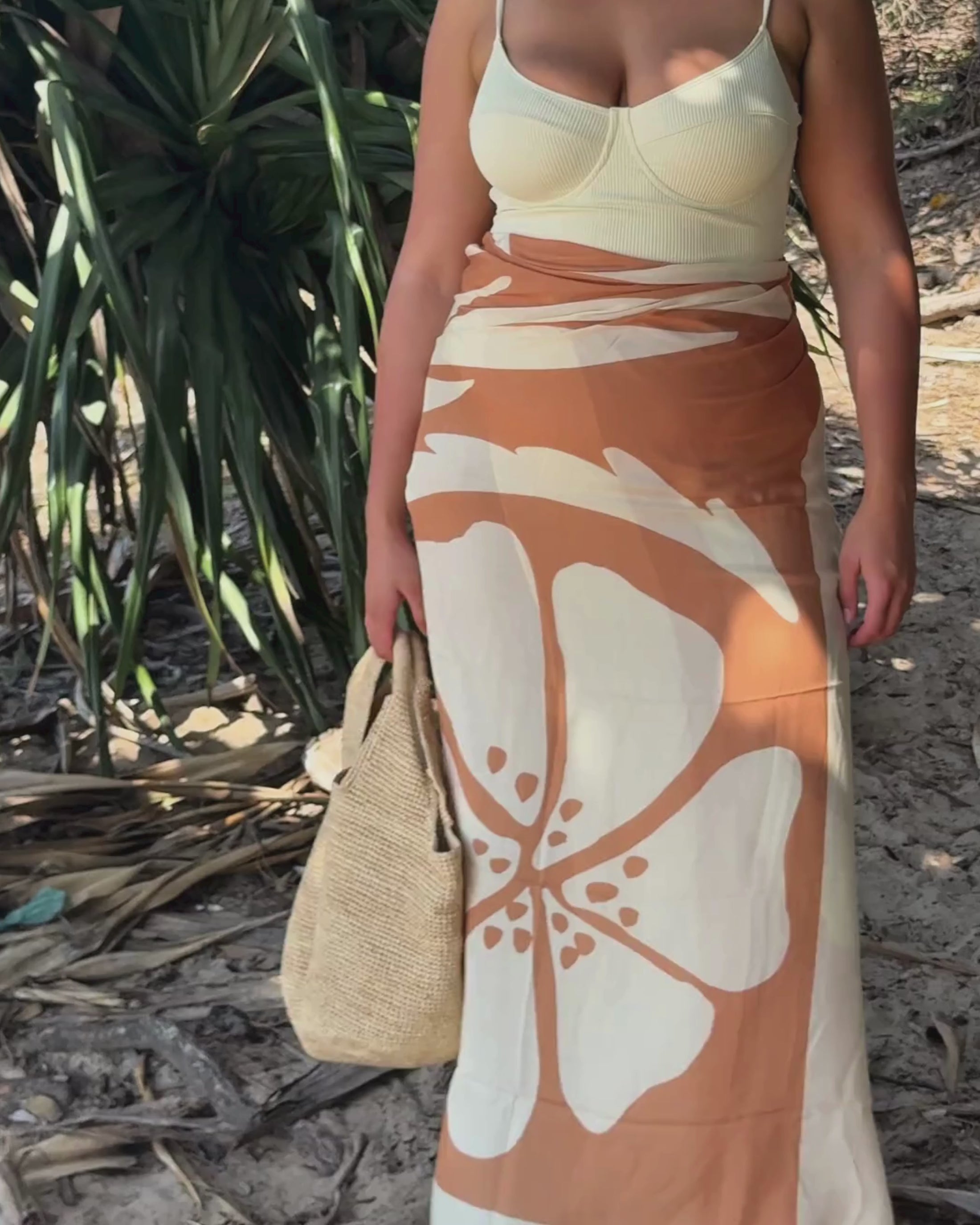 Ochre Lane Sienna sarong styled with swimwear, featuring earthy tones and large floral print, perfect for summer getaways.