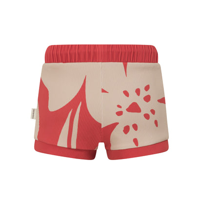 Back view of red kids swim shorts showing the cream hibiscus print and ribbed red cuffs