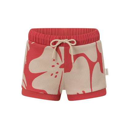 Front view of red kids swim shorts with a cream hibiscus floral print, elasticated red waistband and drawstring