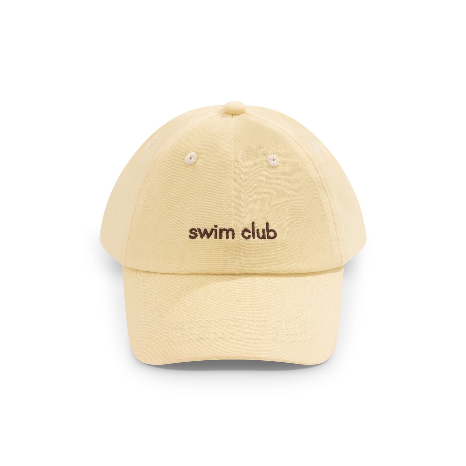 Girl wearing a pale yellow swim club baseball cap and brown and cream print swimsuit at the beach
