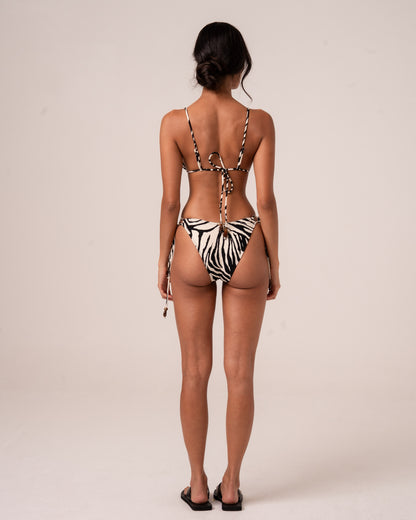 Back view of zebra print string tie-side bikini bottoms with a cheeky seat and wooden bead tie finishing