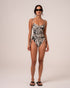 Model wearing a zebra print one-piece swimsuit with a sweetheart underwire neckline, thin adjustable straps, and a ruched side tie waist, studio front view